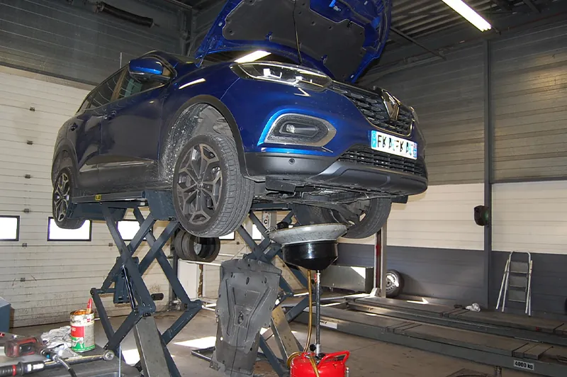 Véhicule sur pont élévateur dans l'atelier mécanique de Toison d'Or Auto